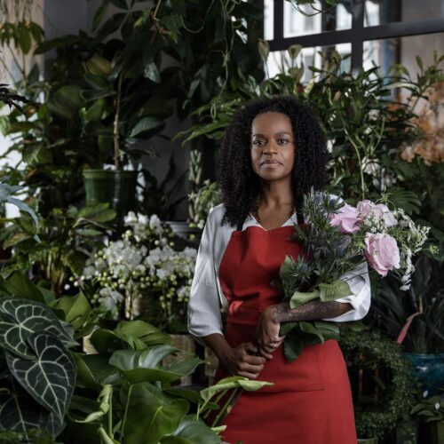 Florist omgiven av växter och blommor